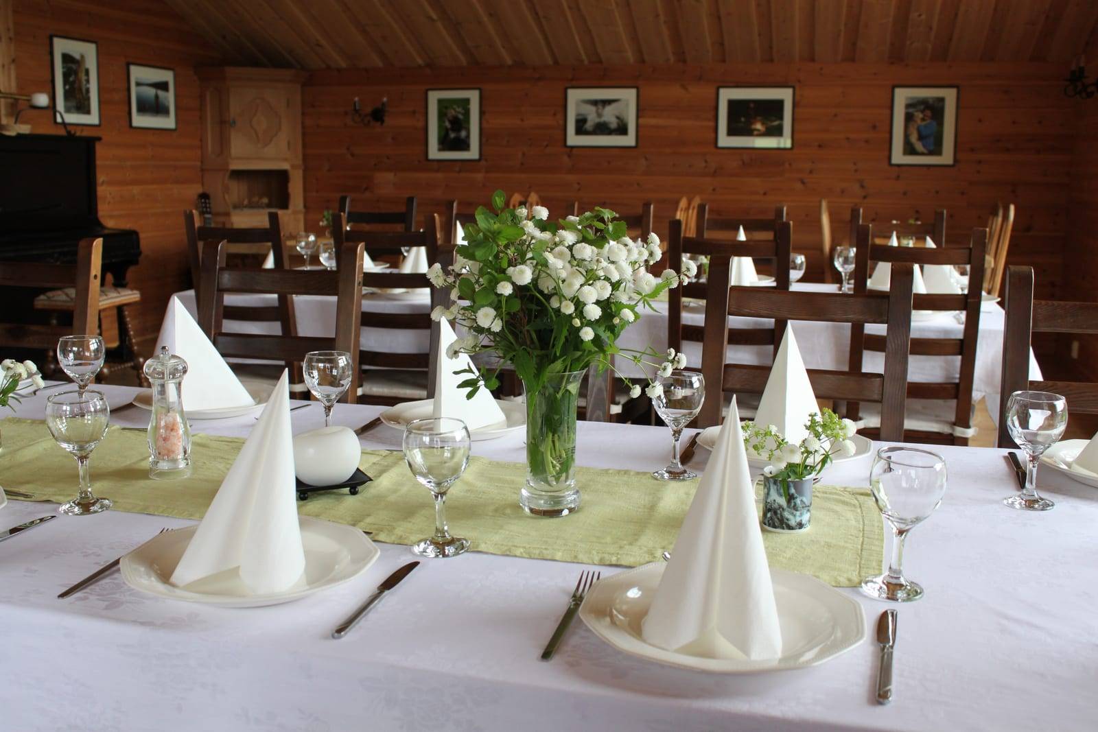 Dekket festbord med hvite servietter og blomster i gårdsrestauranten